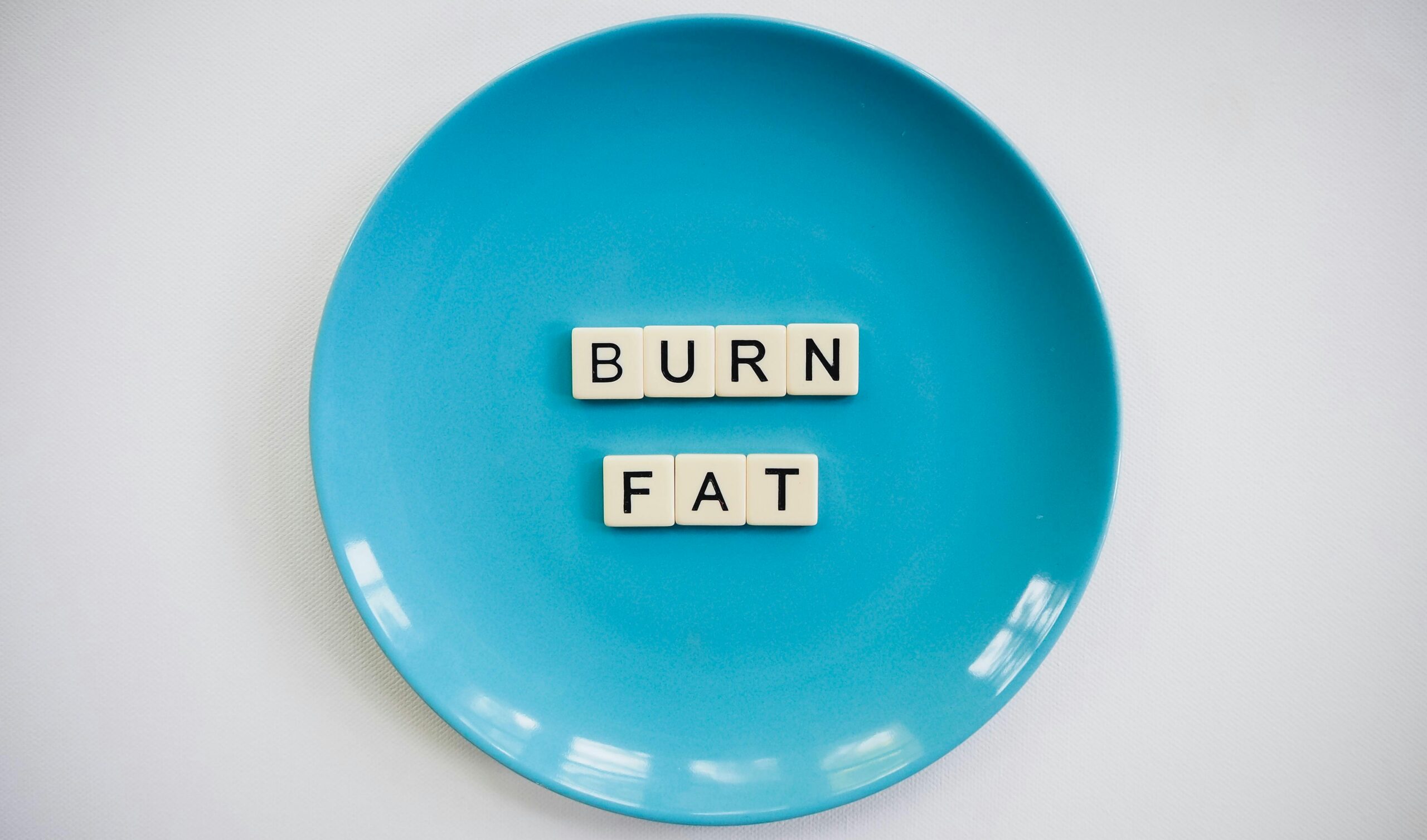 Blue plate with letter tiles spelling burn fat.