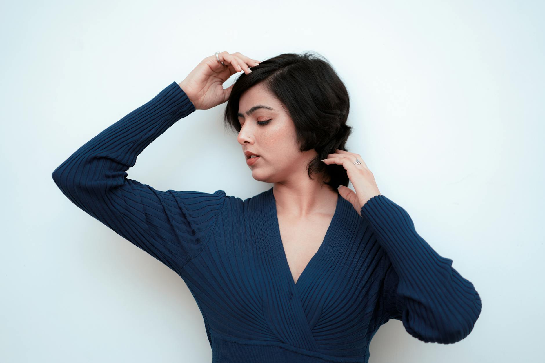 Woman looking thoughtful against a plain background