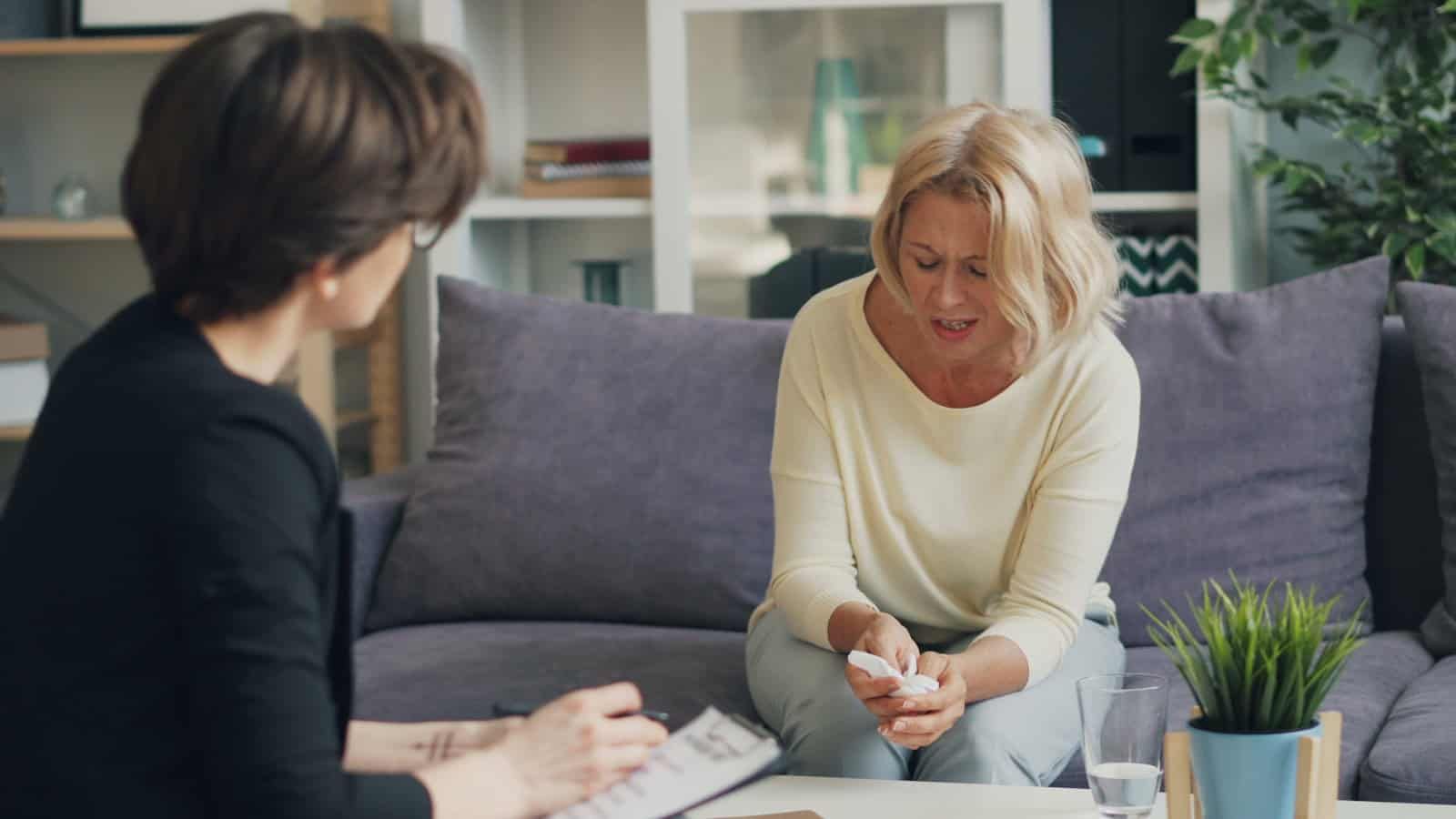 Woman speaking with a therapist during a hypnotherapy session.