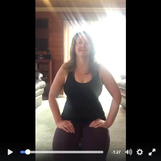 Woman kneeling indoors during a PTSD awareness challenge video.